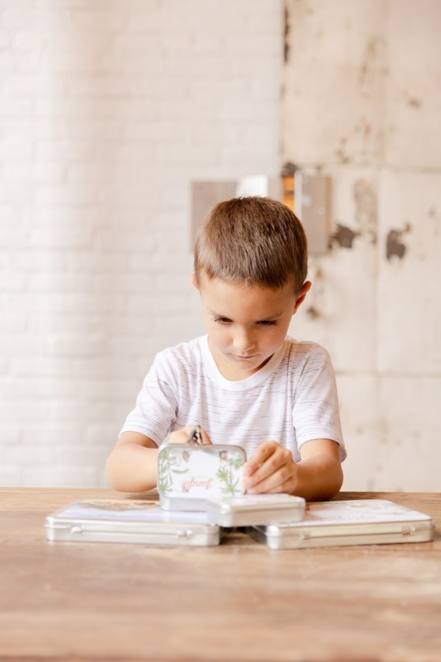 Boy Playing with Mini Animal Tin